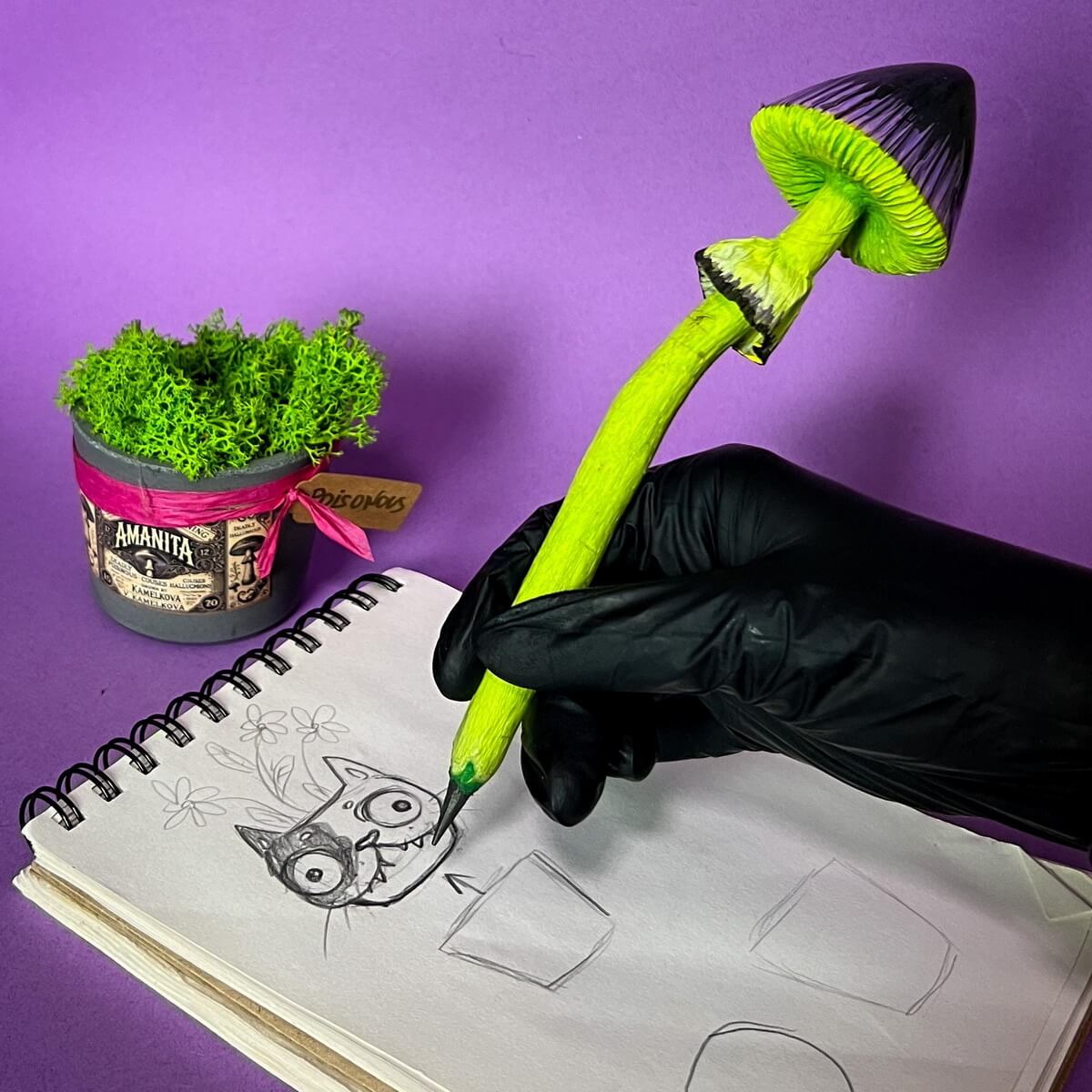 Whimsical green mushroom pencil on sketchbook – colorful papier-mâché art pencil with leaves