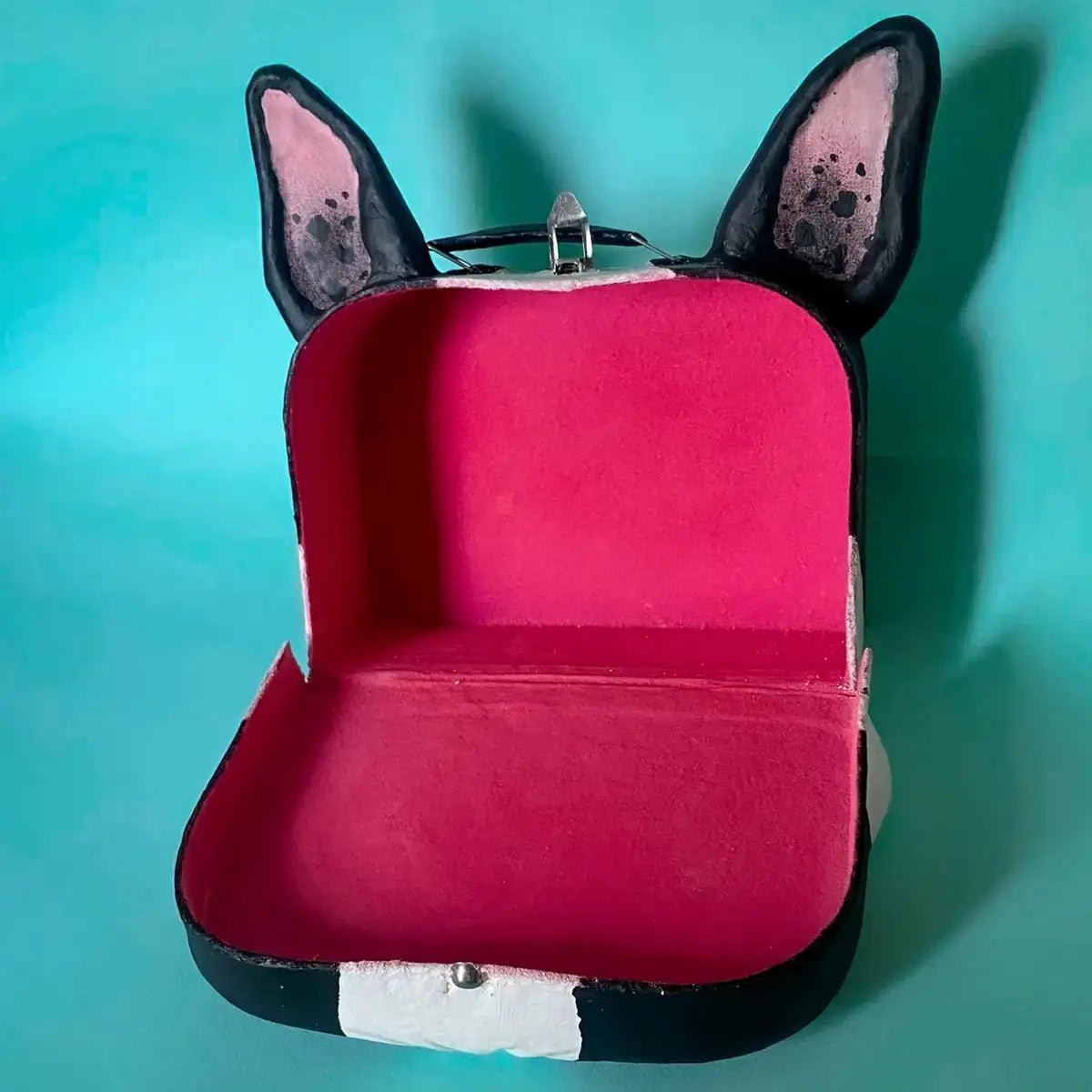 Front view of opened suitcase with pink velvet interior