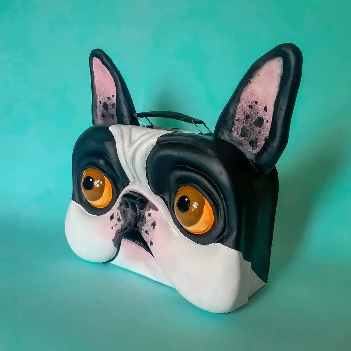 Side view of handmade bulldog suitcase with orange eyes