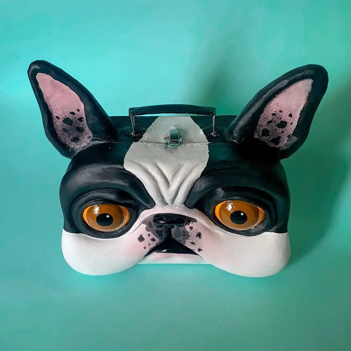 Top view of suitcase with handle and sculpted bulldog face