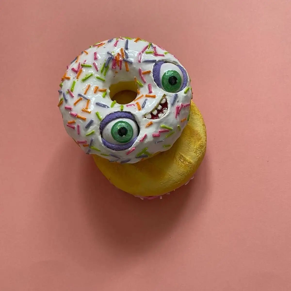White donut sculpture placed on cookie from top view