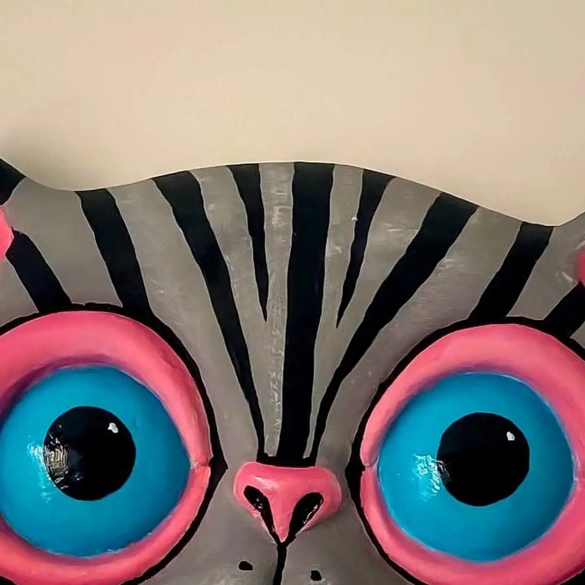 Close-up on eyes and painted fur of gray cat papier-mâché wall decor