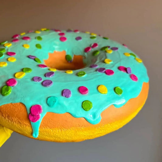 Side view of blue donut sculpture with glaze and sprinkles