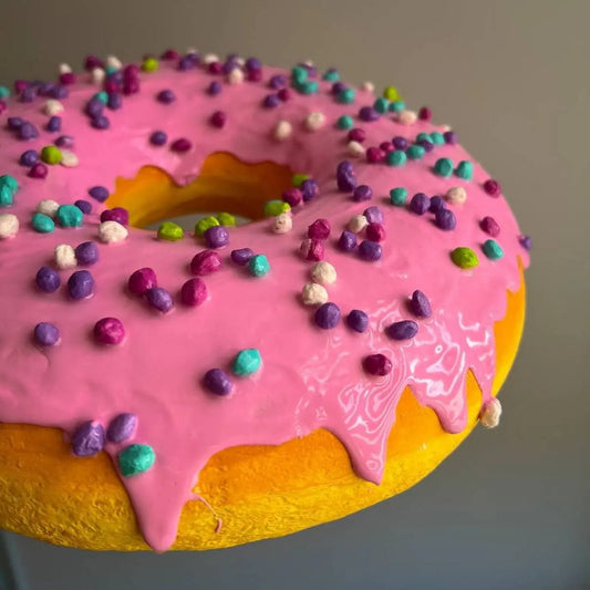 Front view of pink papier-mâché donut – handmade food-themed art