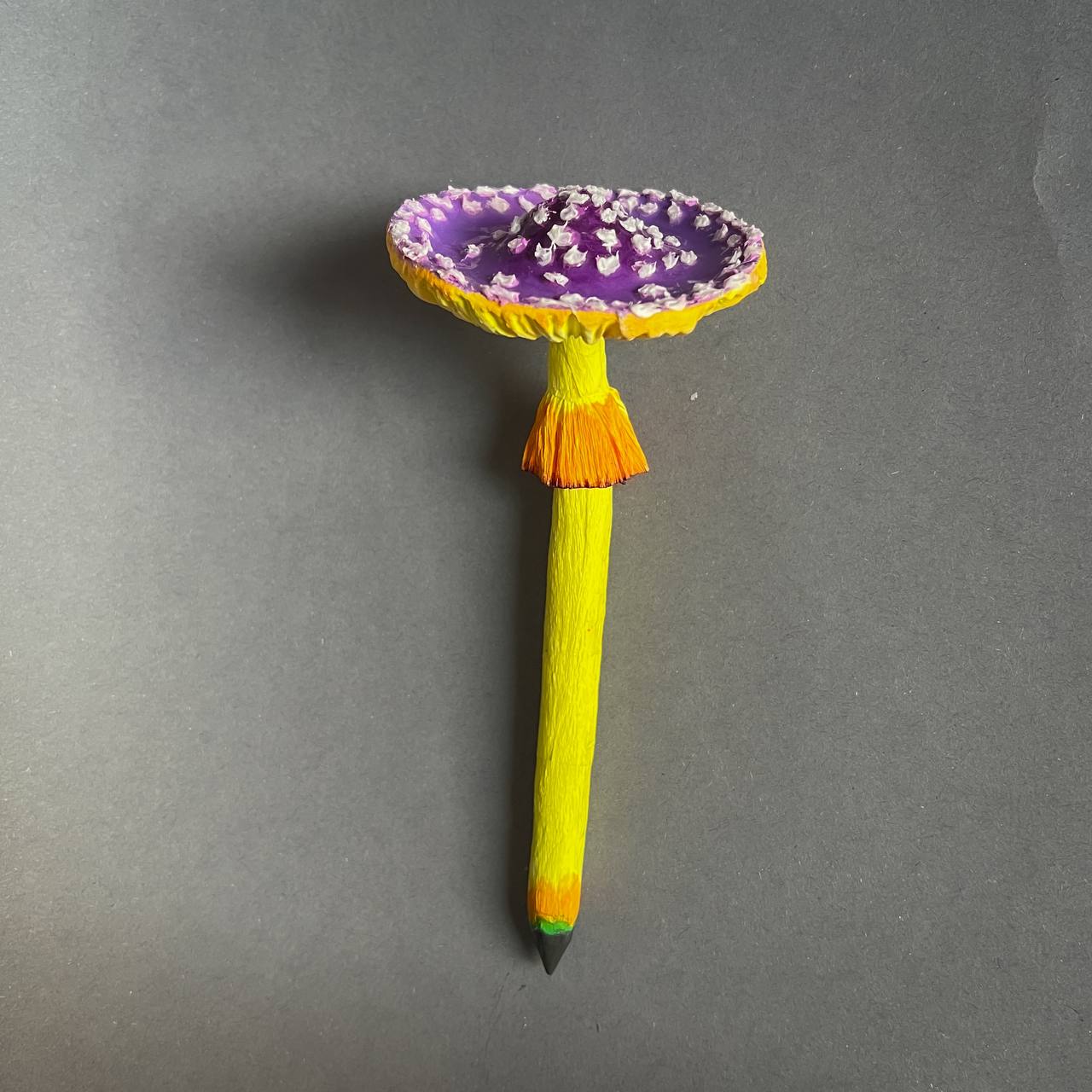 Papier-mâché pencil shaped like a purple mushroom flower with yellow stem – handmade fantasy stationery