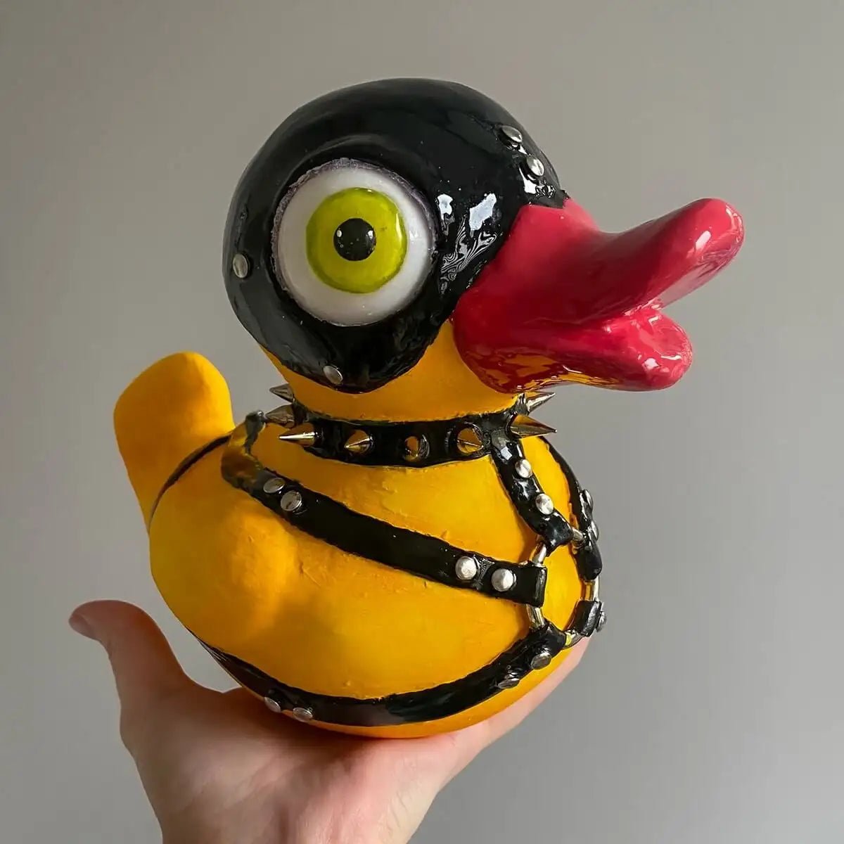 Close-up of duck with leather straps and red beak – angled view