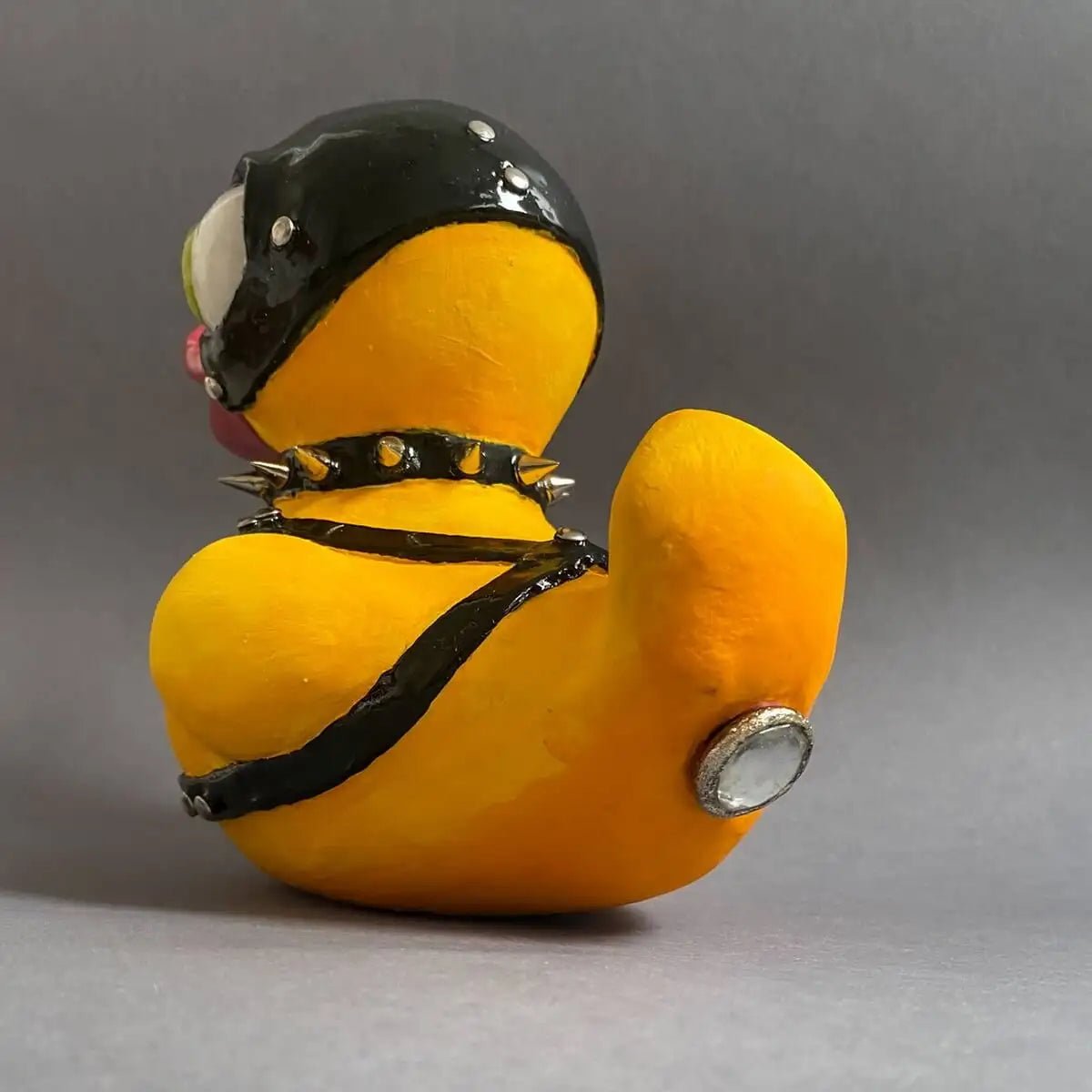 Side profile of BDSM-themed duck sculpture – helmet and eye visible