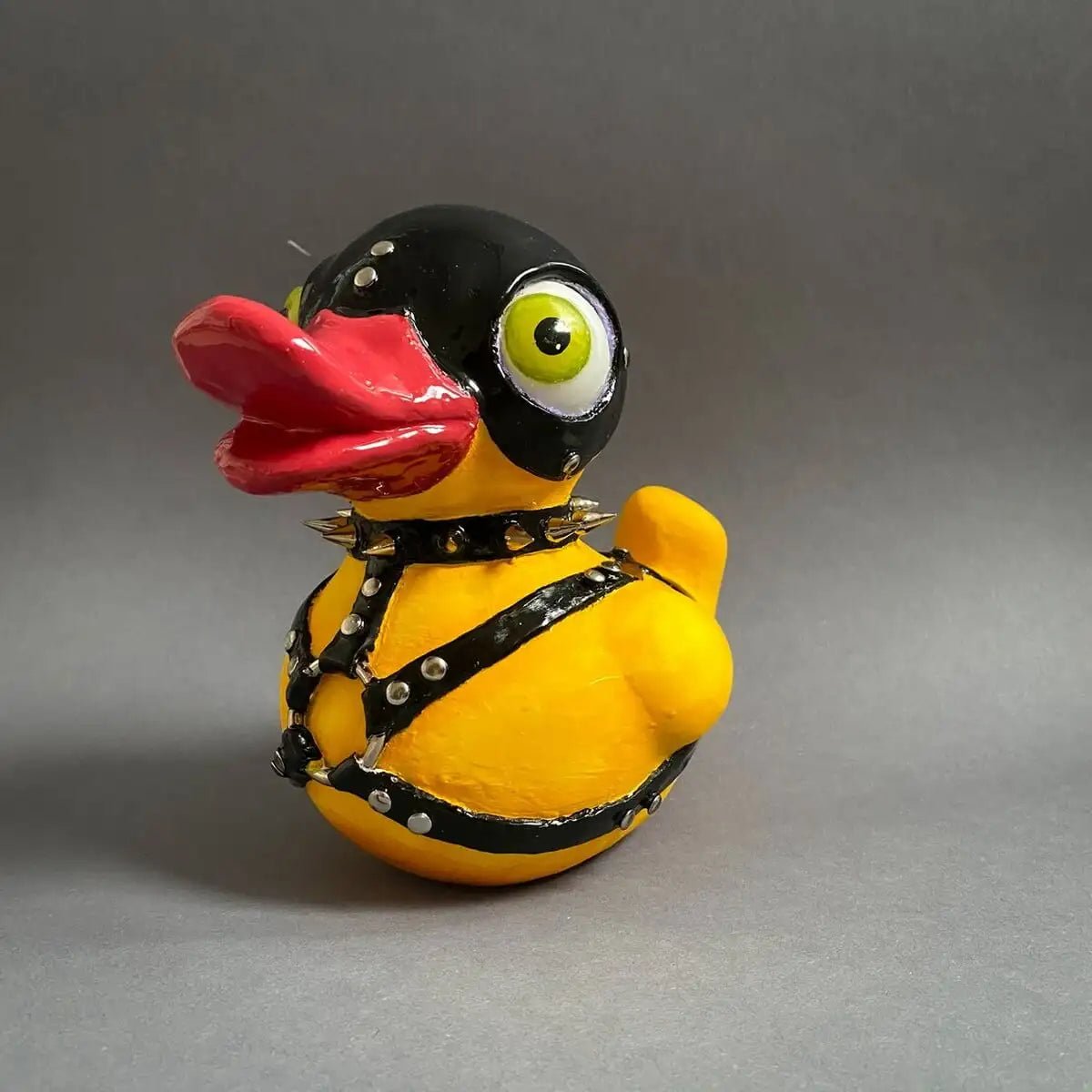BDSM duck sculpture on gray background – front angle with leather gear