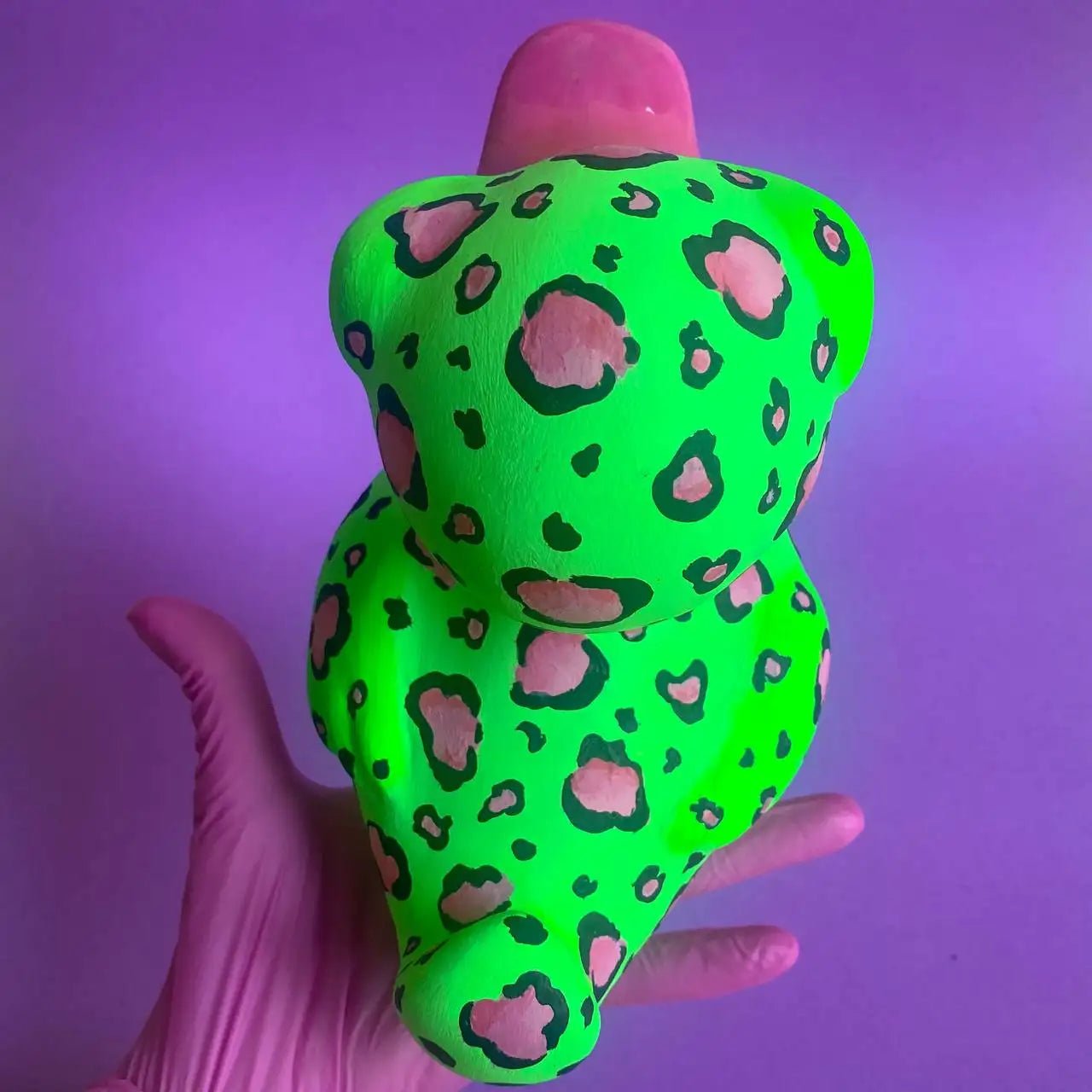 Back view of bold leopard duck figurine on purple background