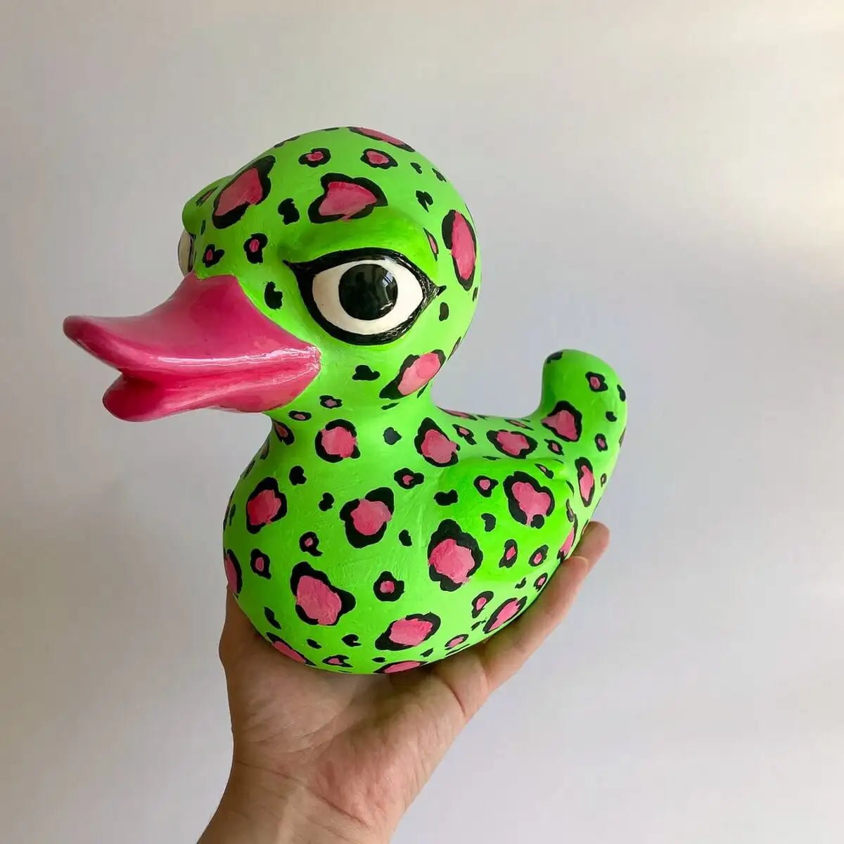 Handmade duck sculpture held in hand, facing forward
