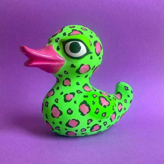 Leopard-print papier-mâché duck figurine on purple background, side view