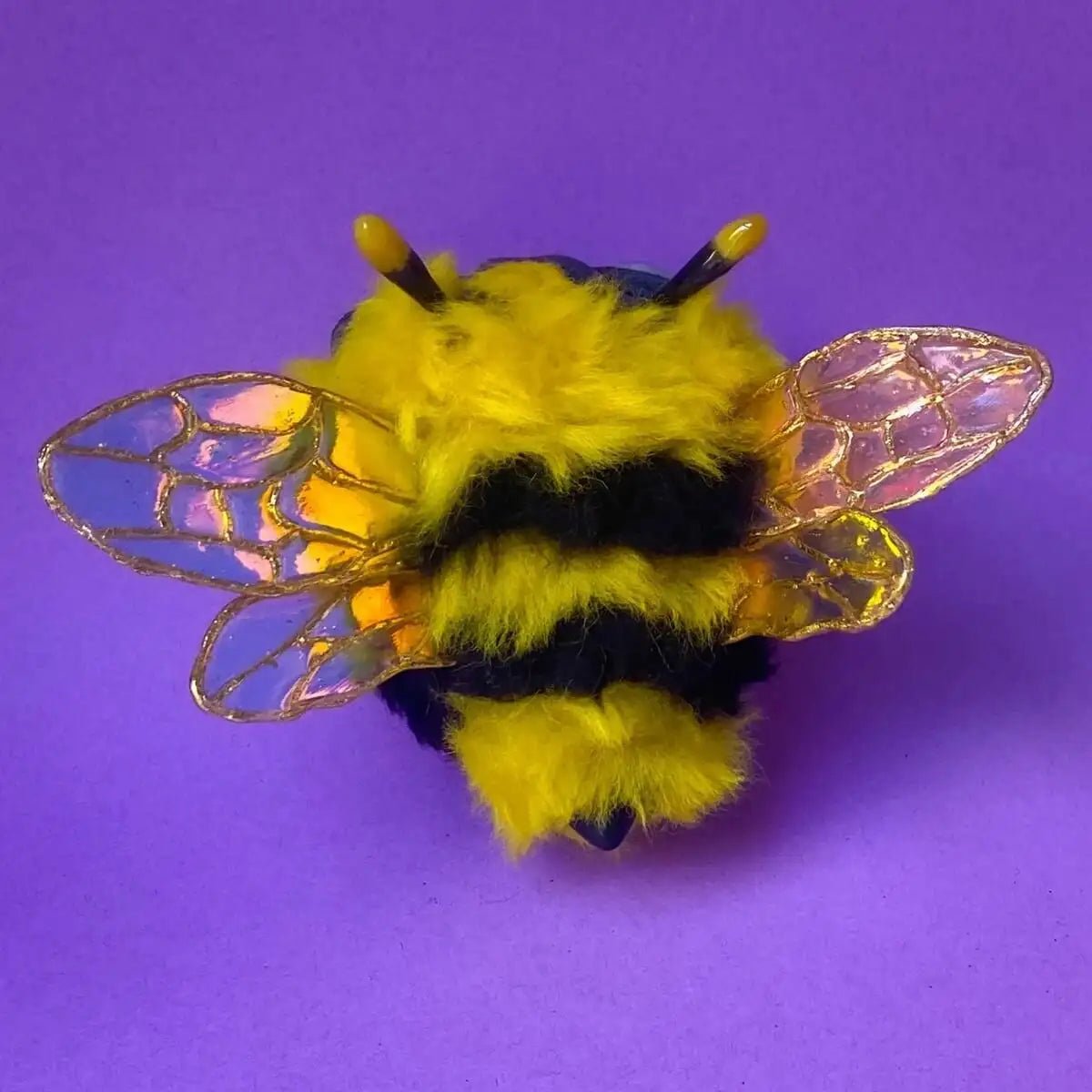 Back view of bee sculpture with striped pattern and transparent wings
