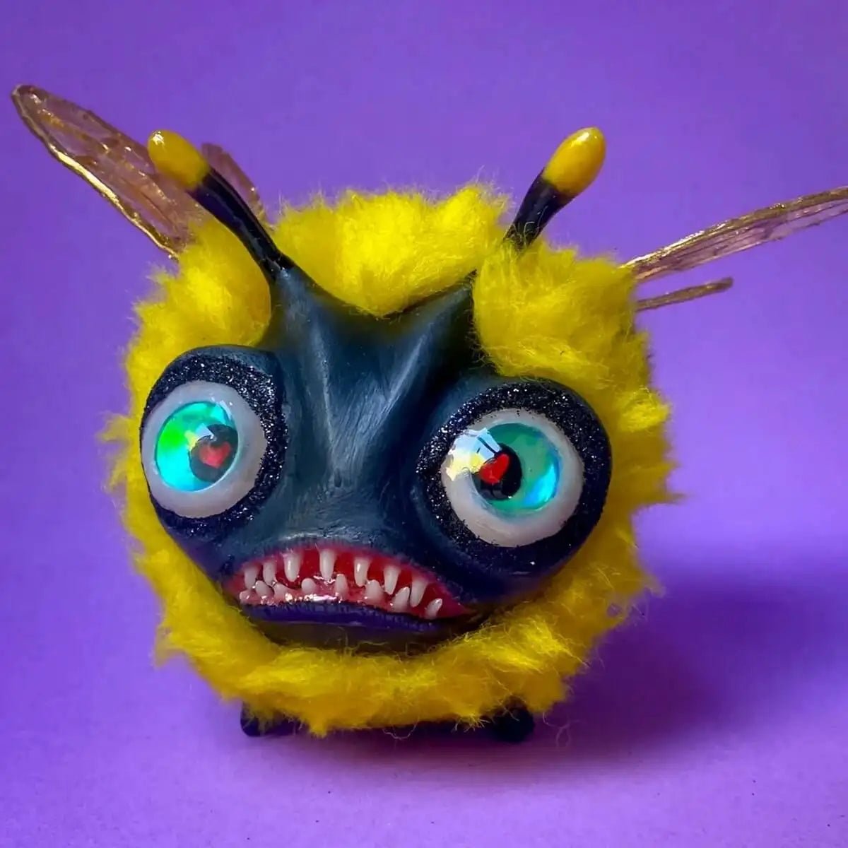 Front view of handmade fluffy bee sculpture with big eyes and yellow wool