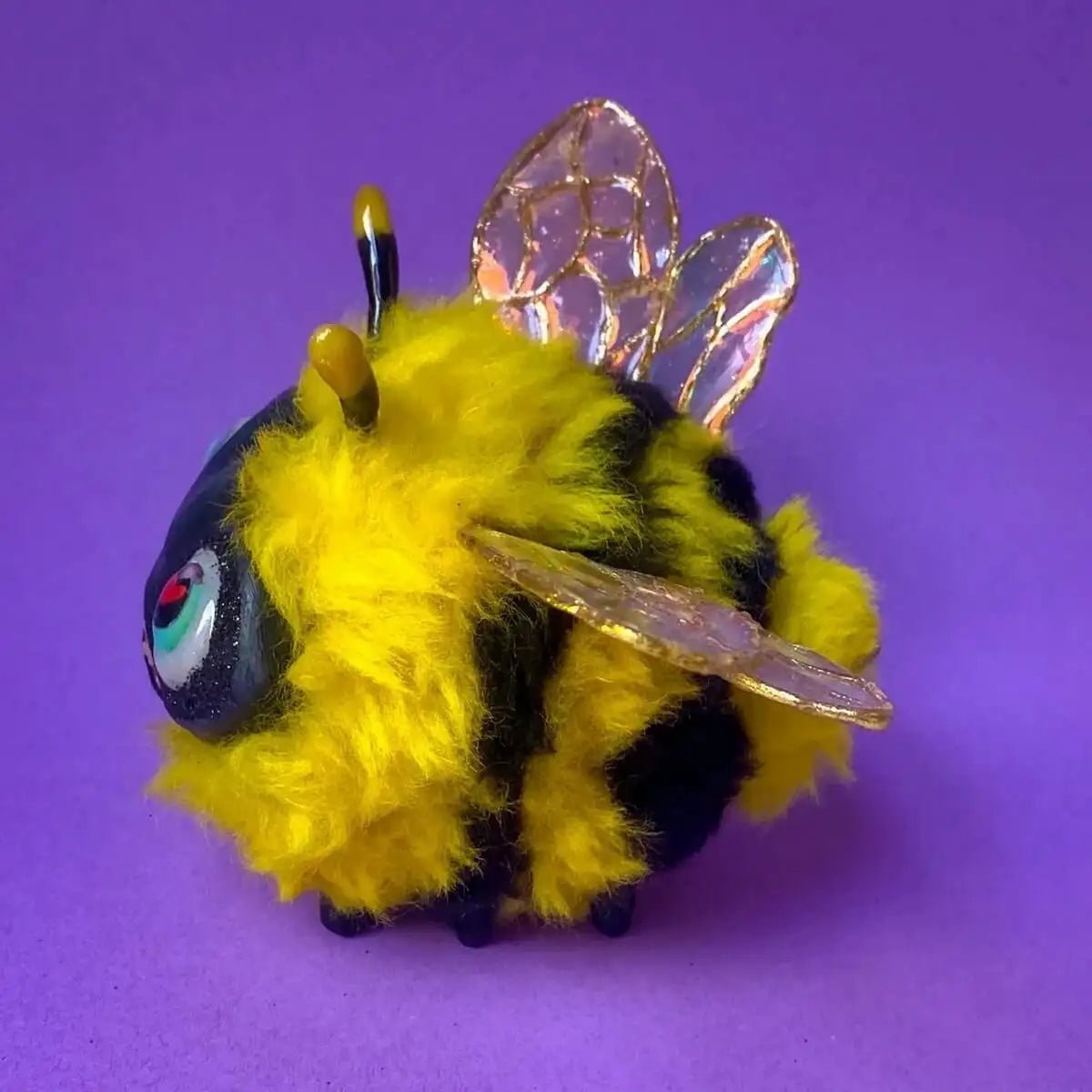 Left side of handmade bee sculpture showing wool texture and wings