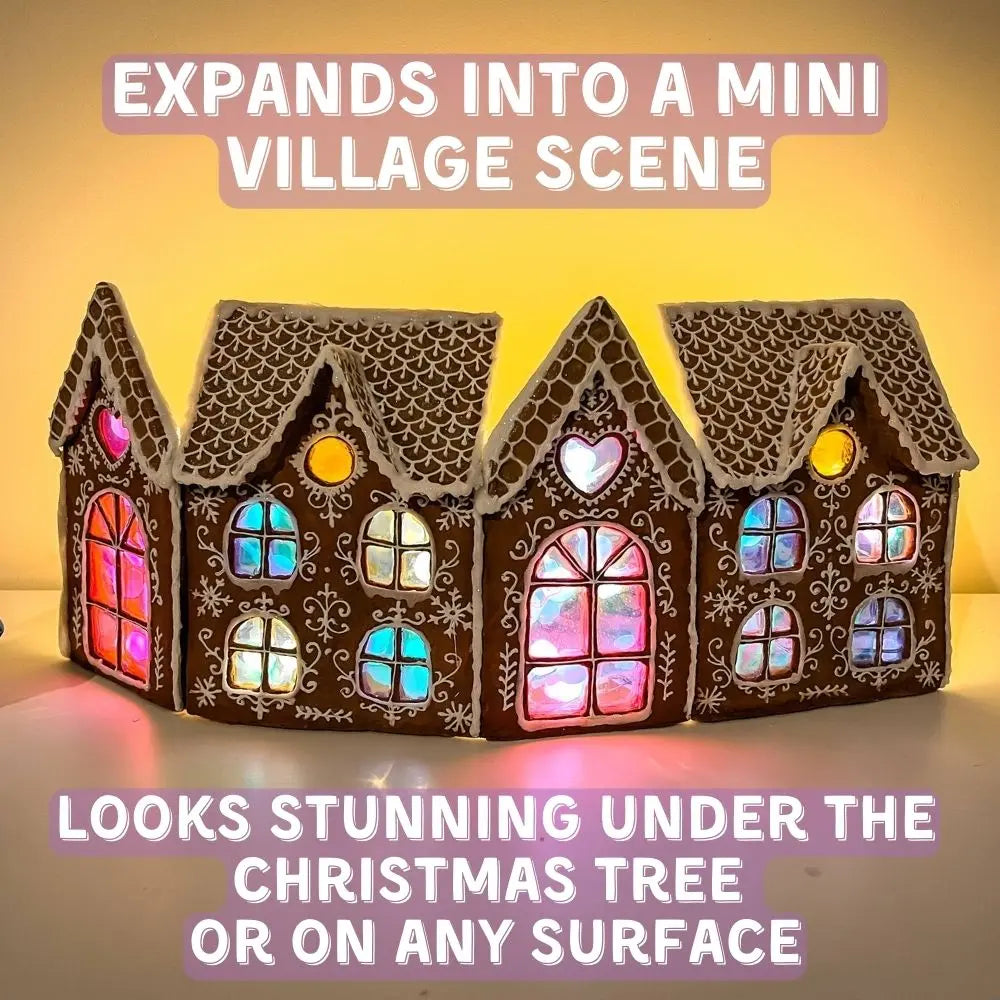 Papier-mâché gingerbread house unfolded into a full mini village scene with colorful illuminated windows