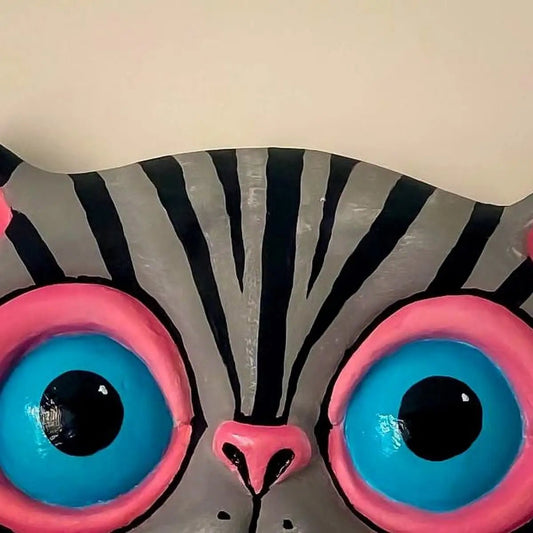 Close-up on eyes and painted fur of gray cat papier-mâché wall decor