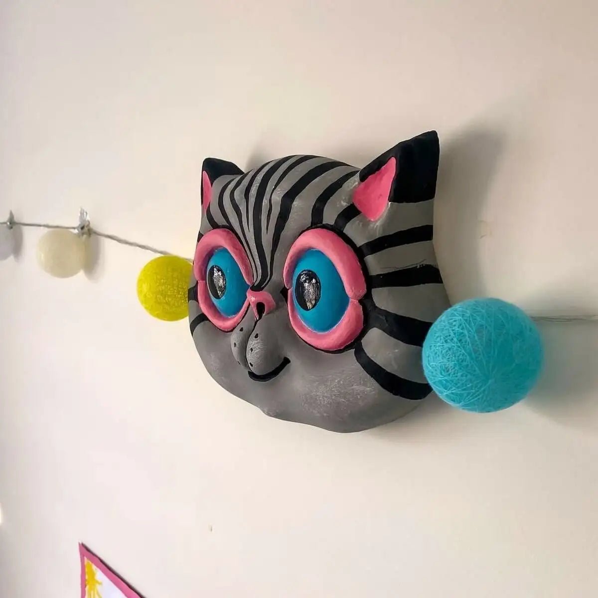 Right angle of gray papier-mâché cat sculpture on the wall