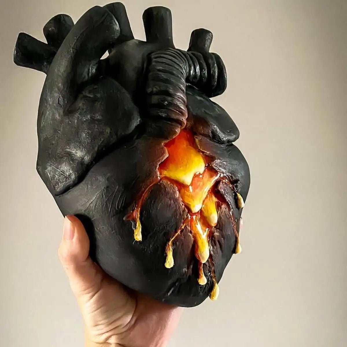 Front view of heart lava vase held in hand, showing glow detail