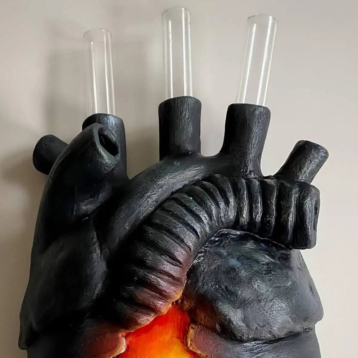 Side view of black heart vase with inserted glass tubes