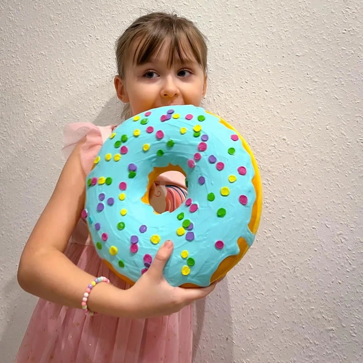 Girl holding large papier-mâché donut – fun decor for kids' room