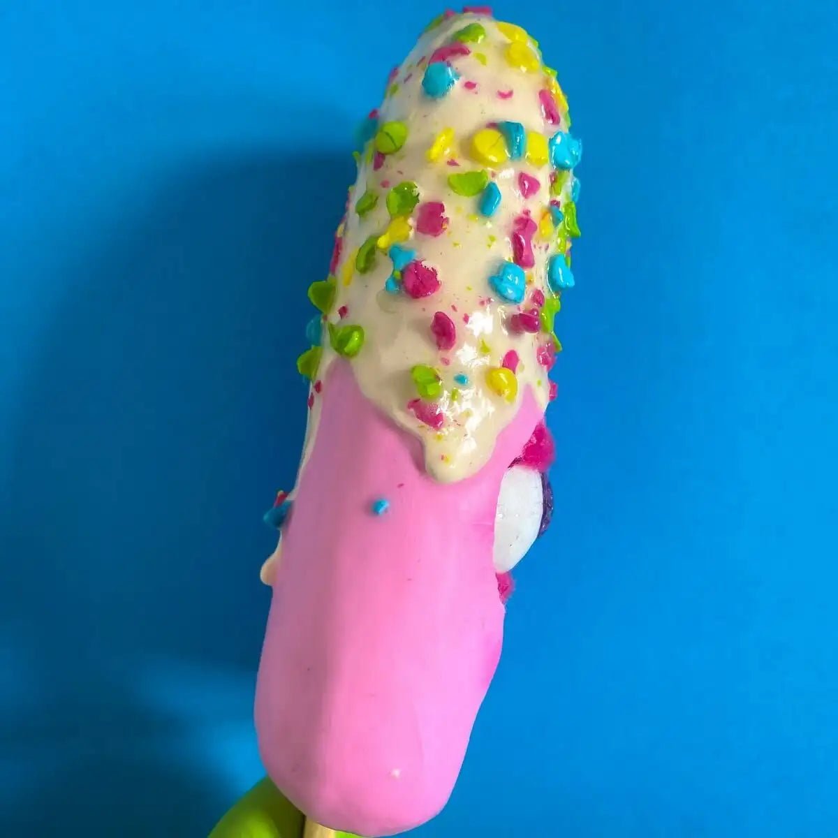 Side view of pink ice cream figurine showing textured topping
