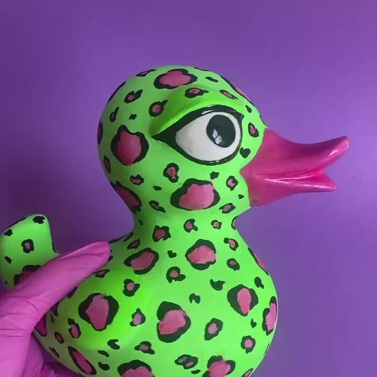 Video of leopard duck figurine rotating on purple background