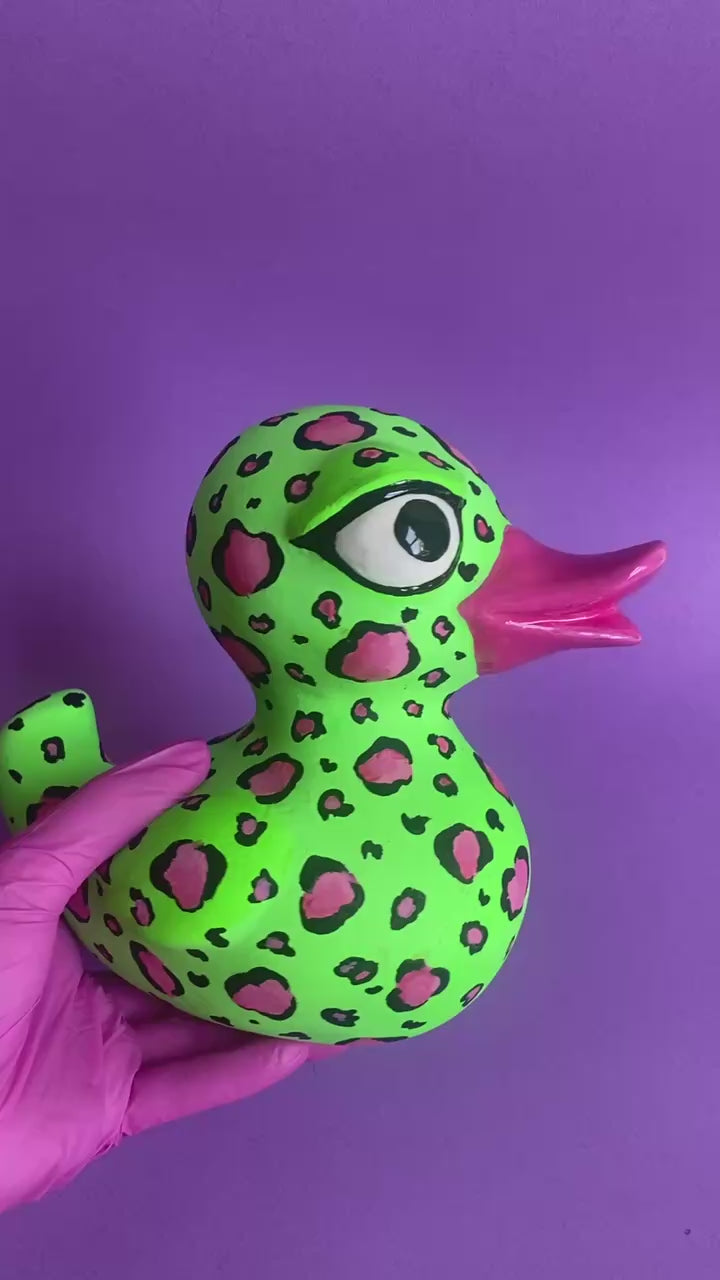 Video of leopard duck figurine rotating on purple background