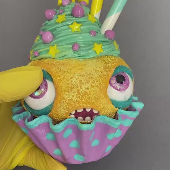 Video showing cupcake with moving eyes and real candle in multiple angles