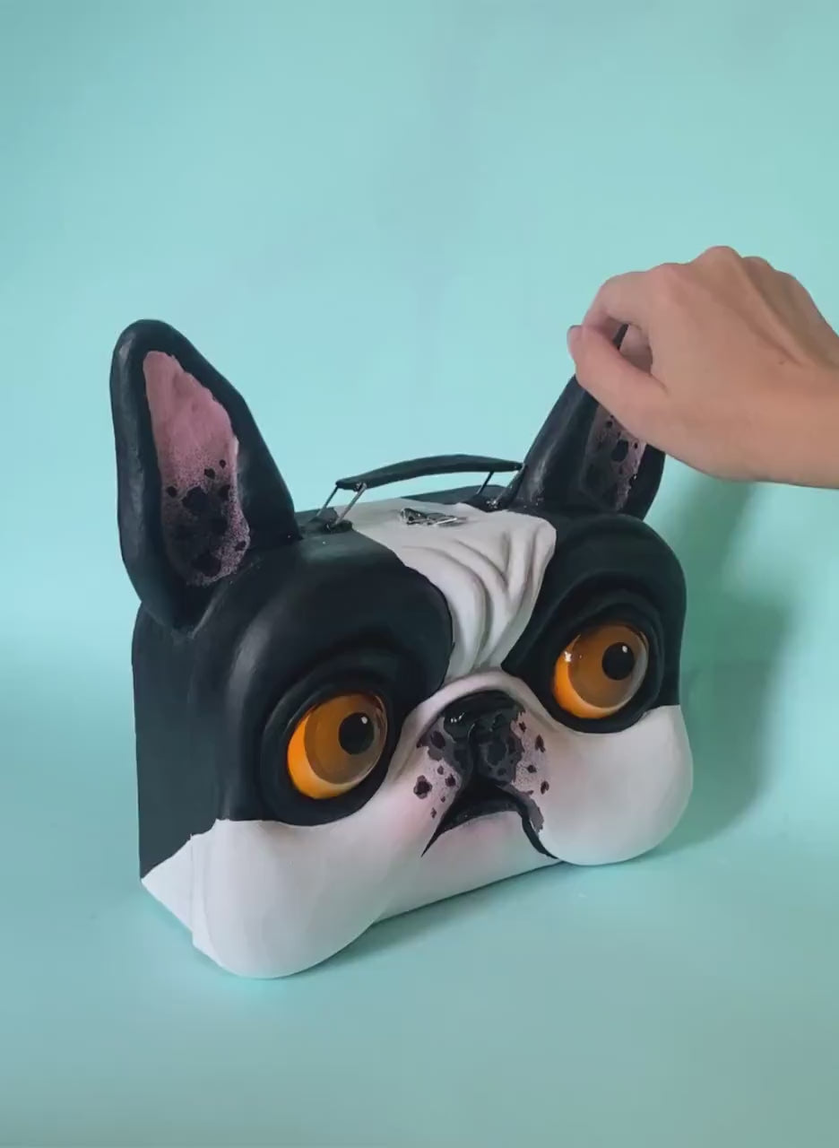 Video showing papier-mâché bulldog suitcase being opened and rotated in hand