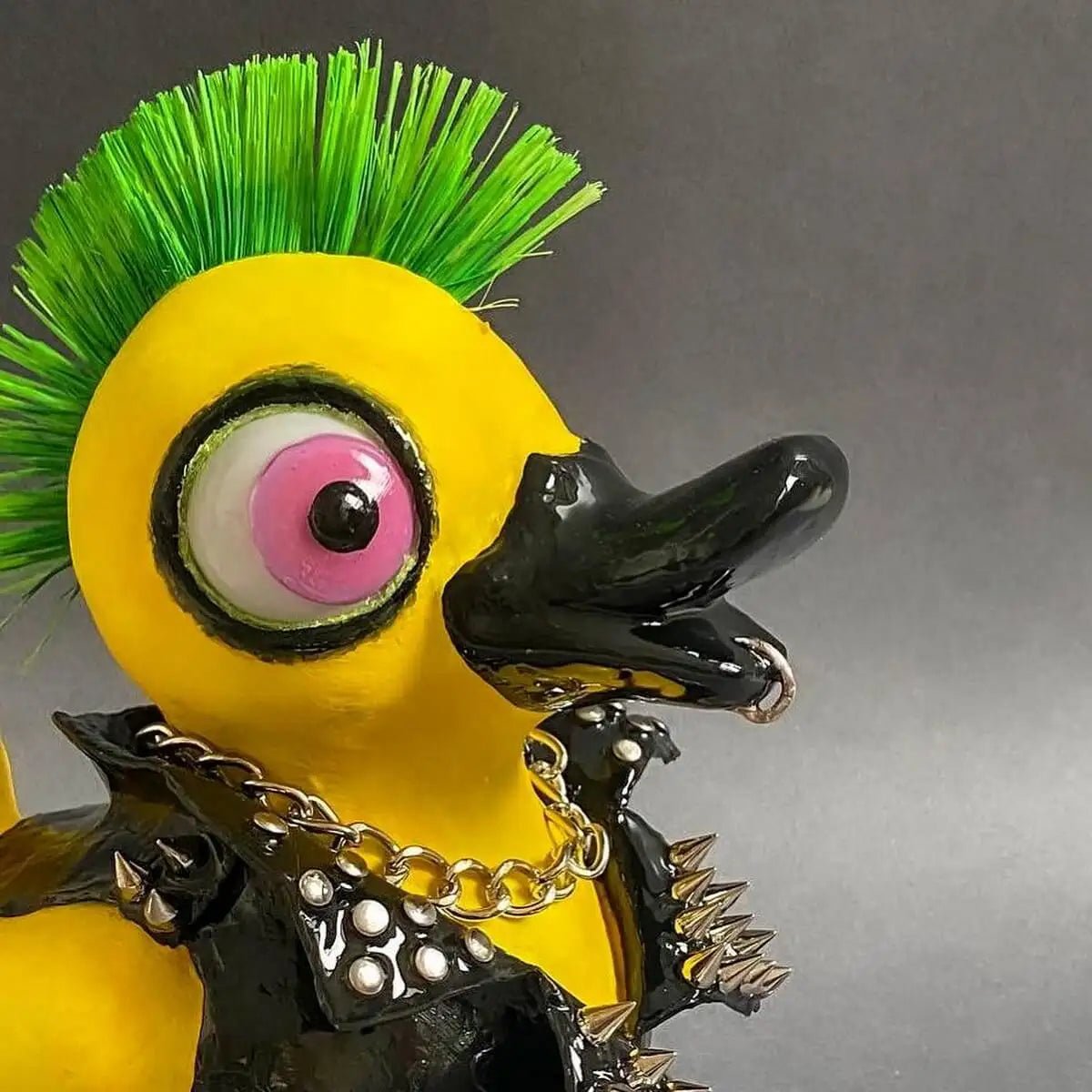 Close-up of punk duck’s face – pink eye and green mohawk