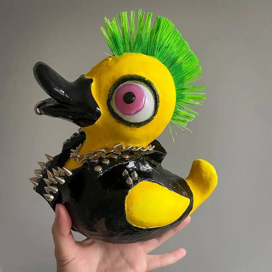 Handmade punk duck sculpture held in hand – green mohawk and jacket